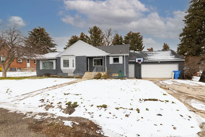 View of front of house featuring brick siding, an attached garage, and driveway