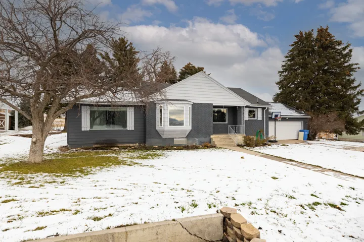 Bungalow-style house featuring brick siding and a garage