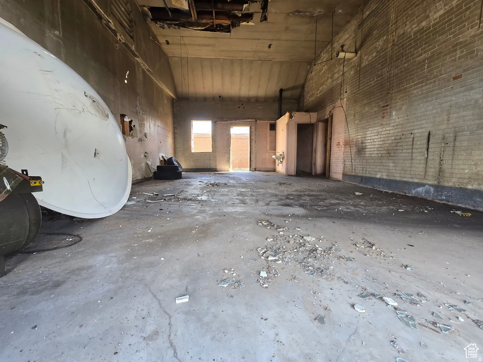 Miscellaneous room featuring a high ceiling, a garage, and concrete flooring