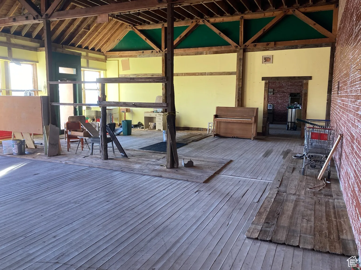 Misc room with hardwood / wood-style flooring and brick wall
