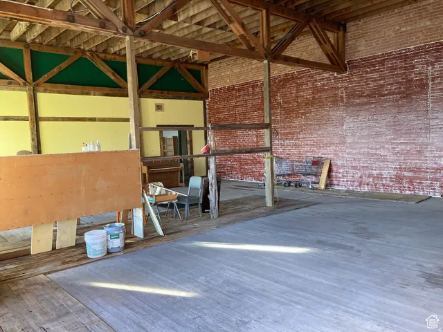 Misc room with brick wall and a towering ceiling