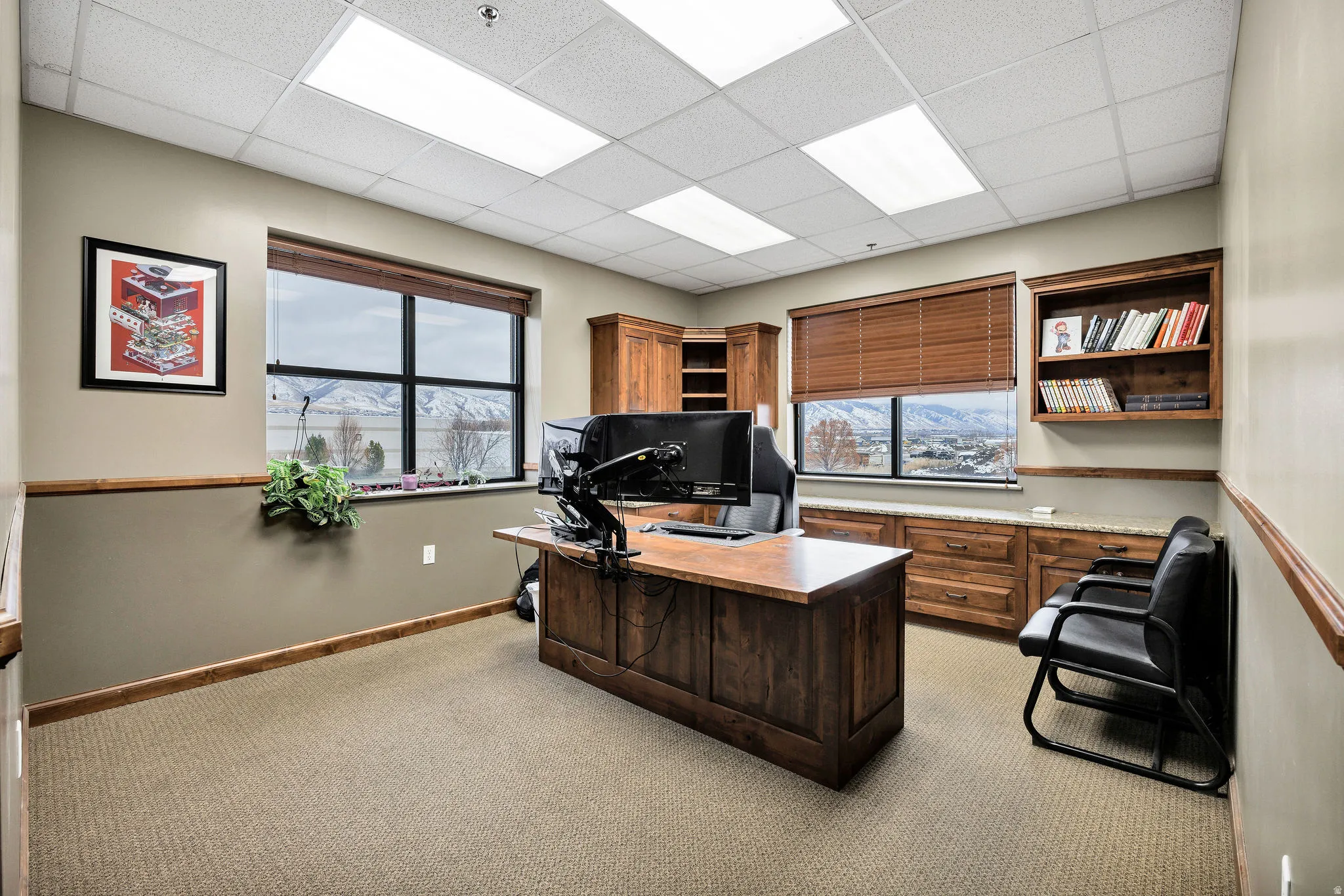 Office space with a drop ceiling, healthy amount of natural light, and light carpet