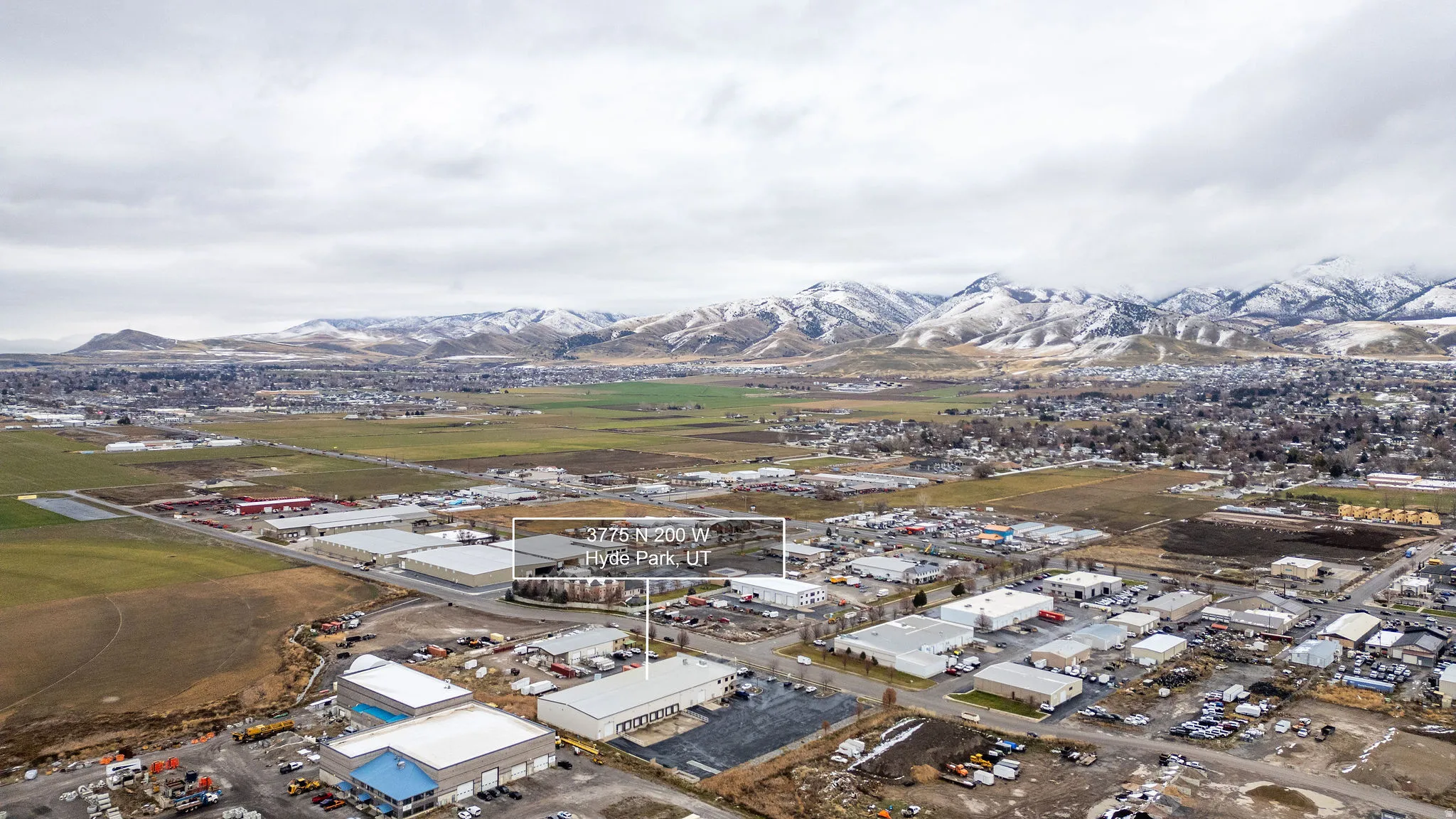 Aerial view of property's location featuring an industrial area and a mountainous background