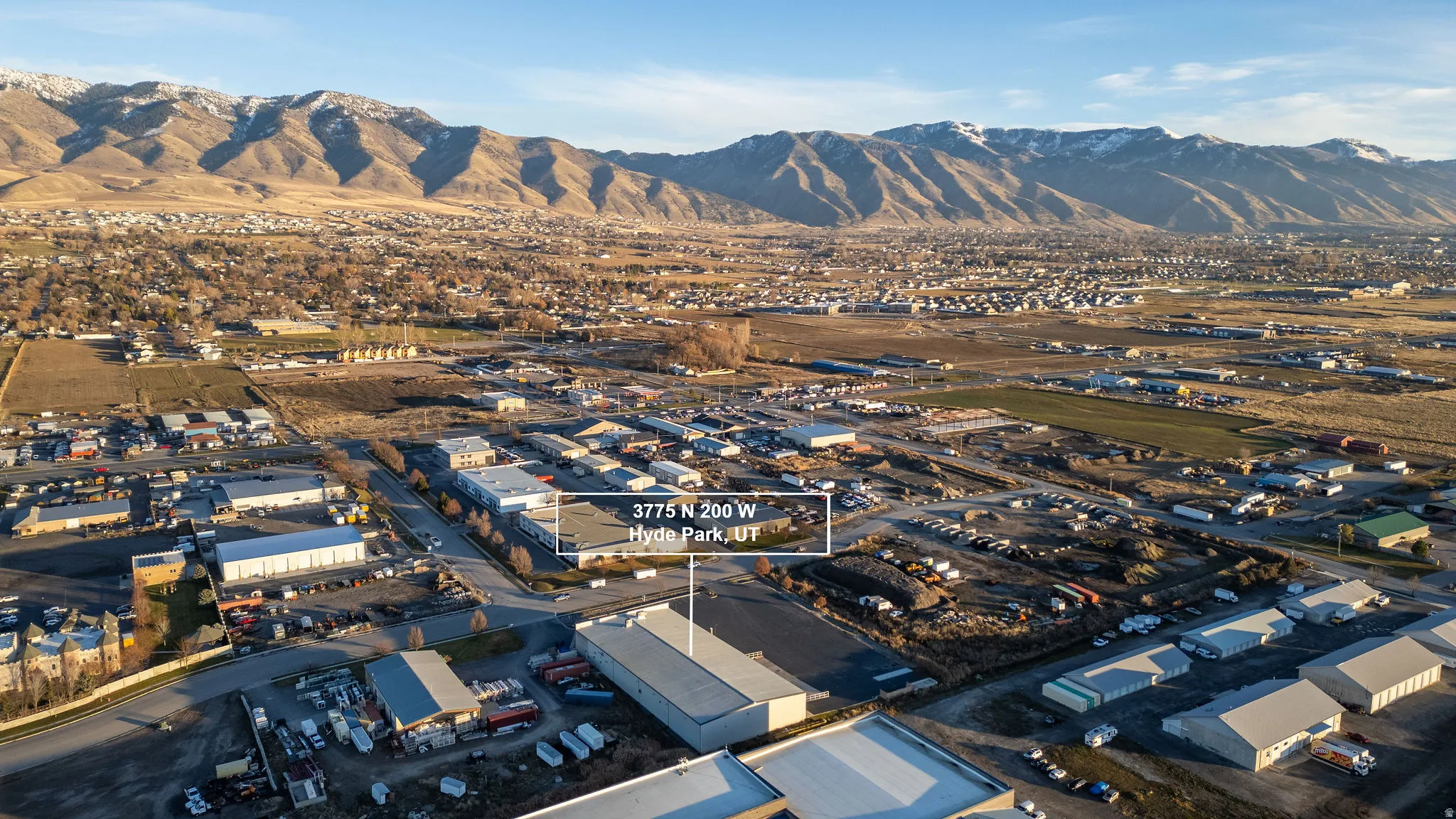 Aerial overview of property's location featuring an industrial area and a mountainous background