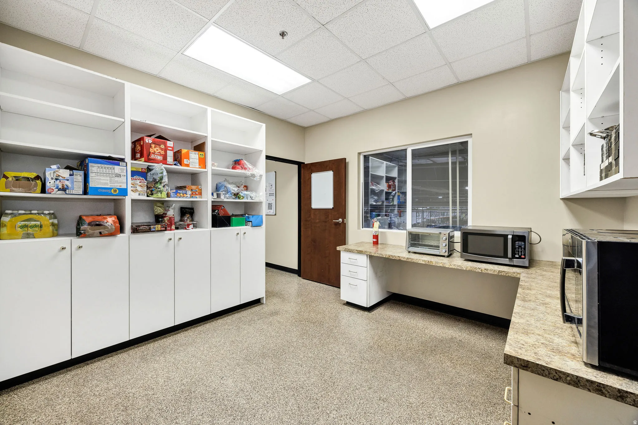 Office area with a drop ceiling and baseboards
