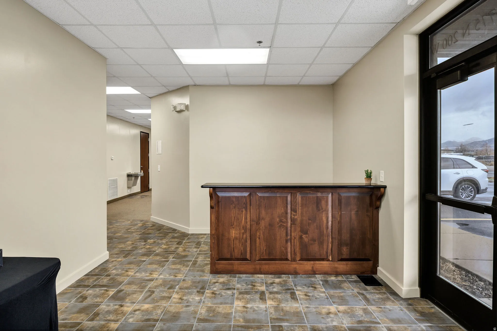 Bar with a paneled ceiling and dark brown cabinetry