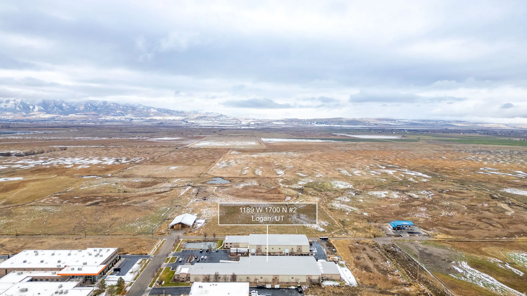 Aerial overview of property's location with a mountain backdrop and rural landscape