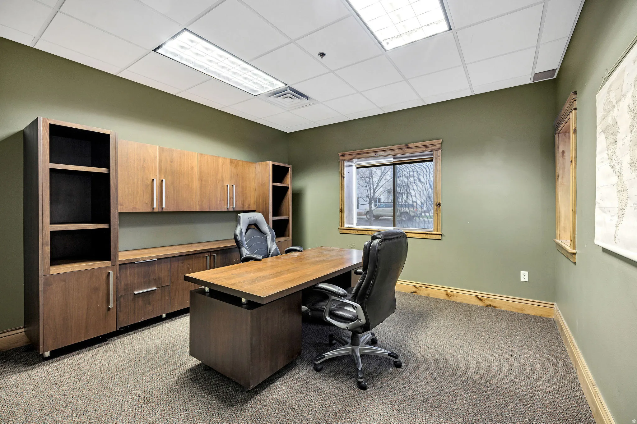 Office space with a drop ceiling and light carpet