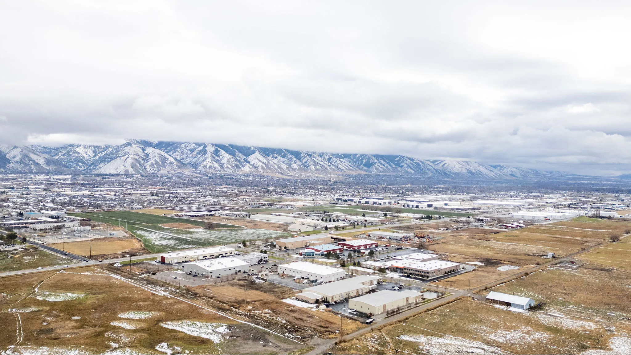 Drone / aerial view of industrial structures and a mountainous background