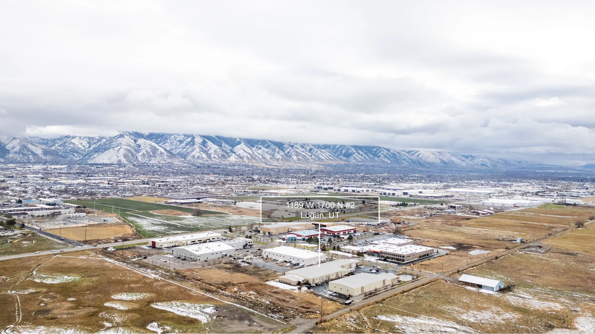 Bird's eye view of industrial structures and a mountain backdrop