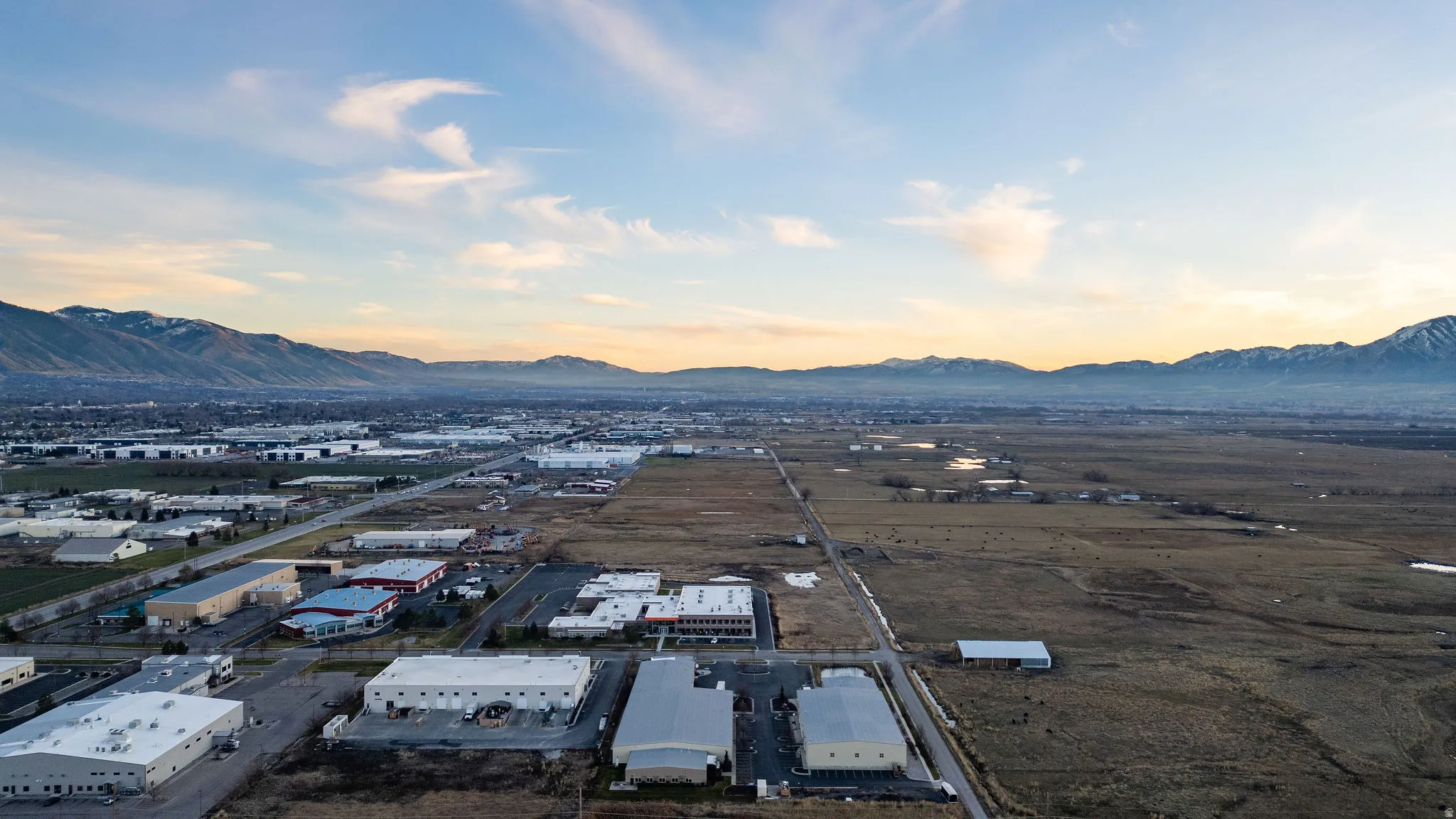 Drone / aerial view of industrial structures and a mountain backdrop