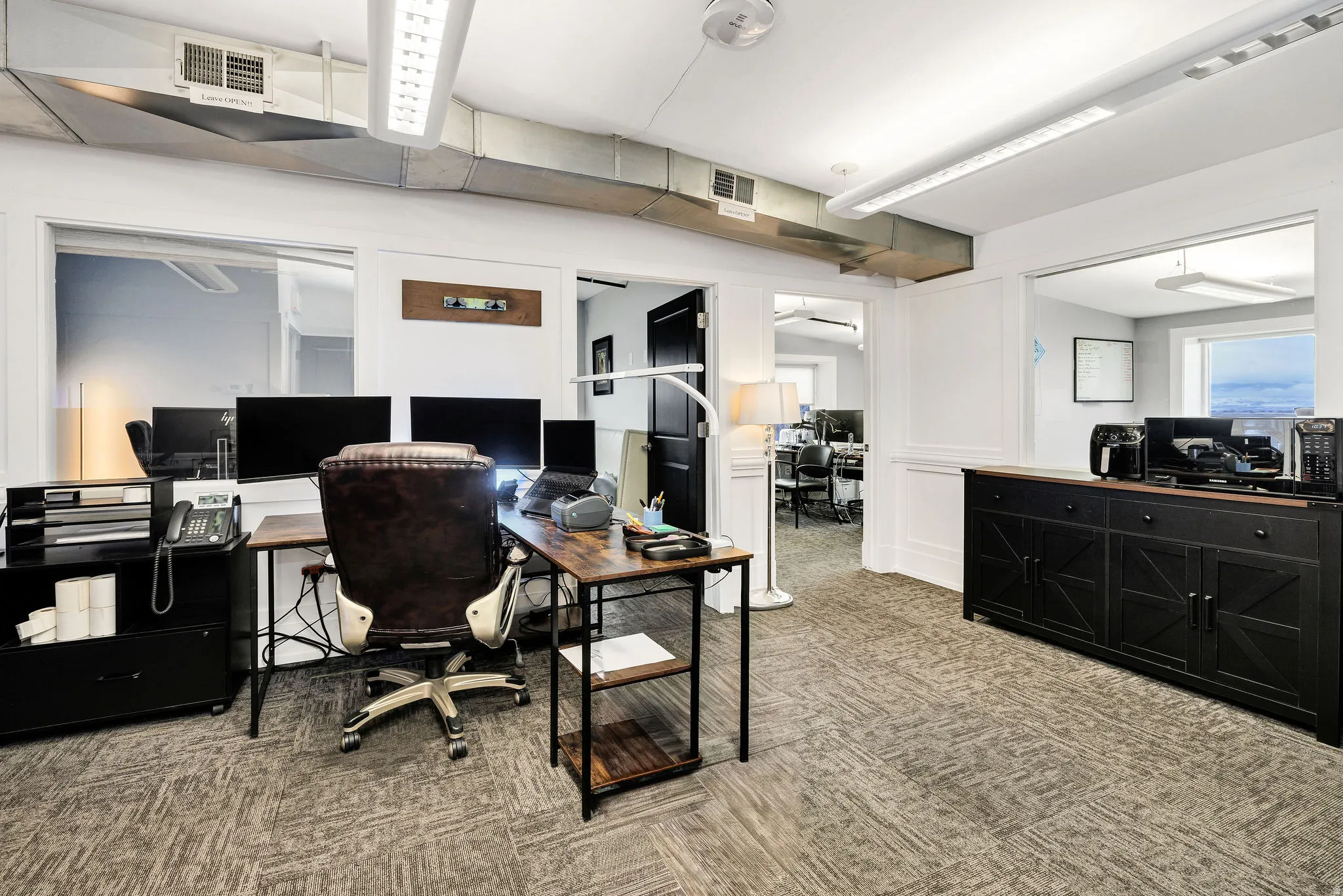 Office area with light colored carpet and ceiling fan