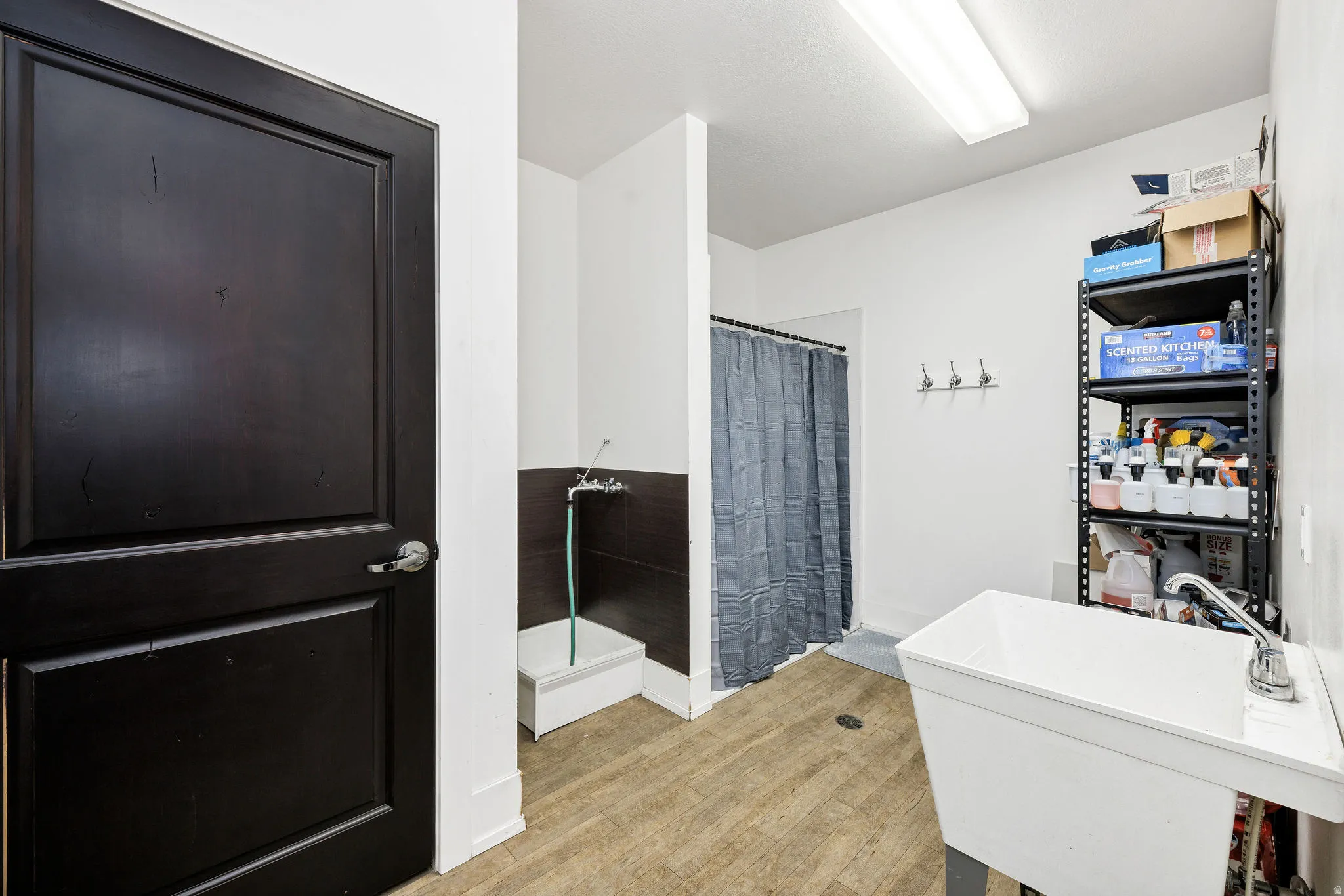 Bathroom featuring a shower stall and light wood-style floors