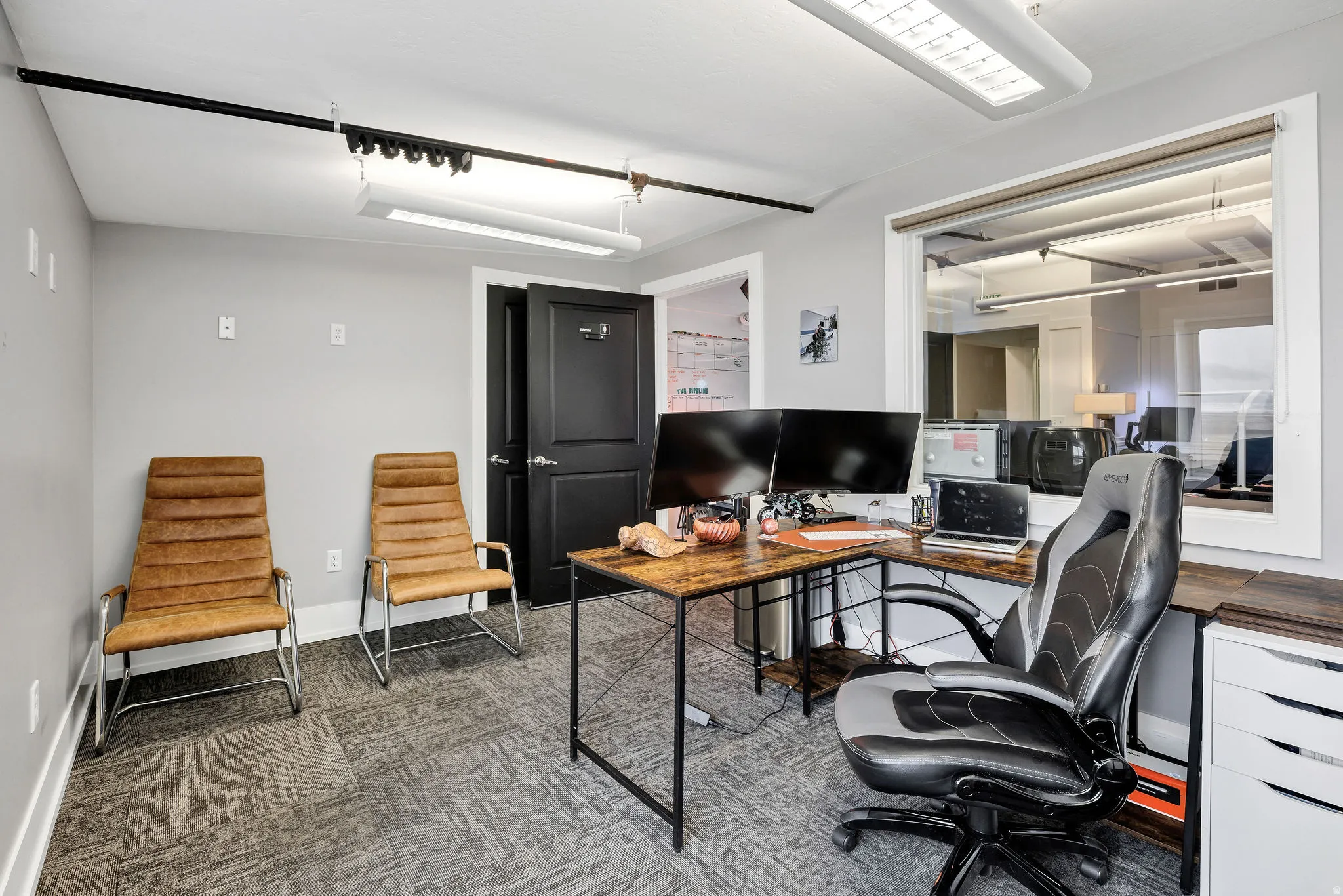 Office with baseboards and dark colored carpet