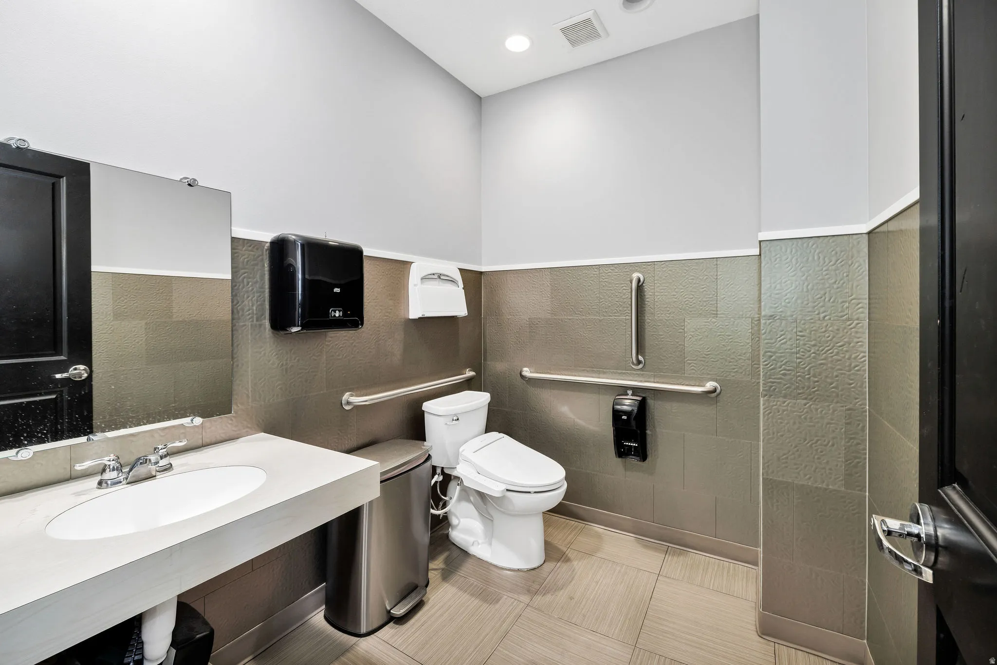 Bathroom featuring tile walls, light tile patterned floors, and recessed lighting