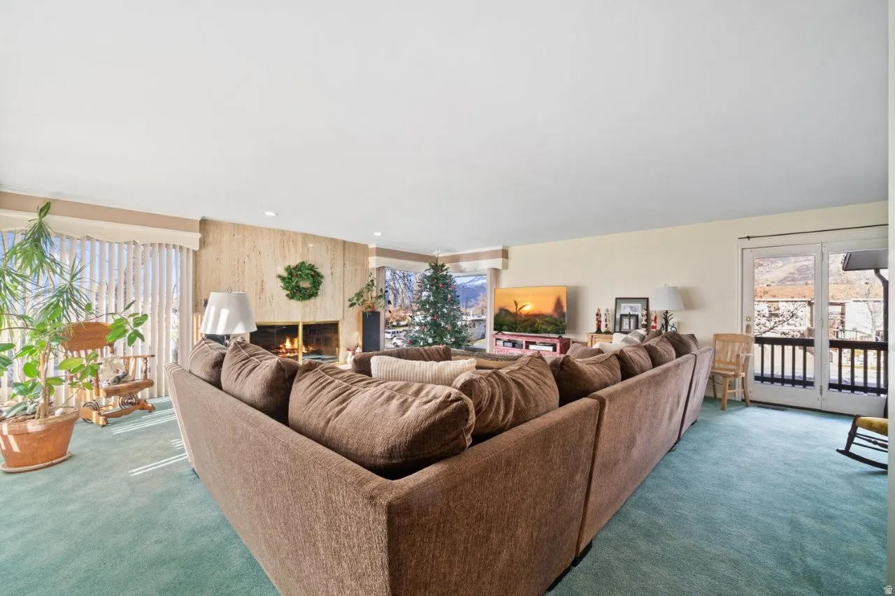 Carpeted living area featuring a large fireplace