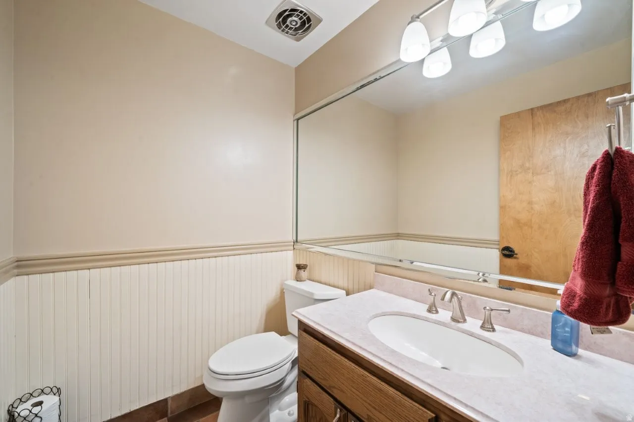 Half bath featuring vanity and wainscoting