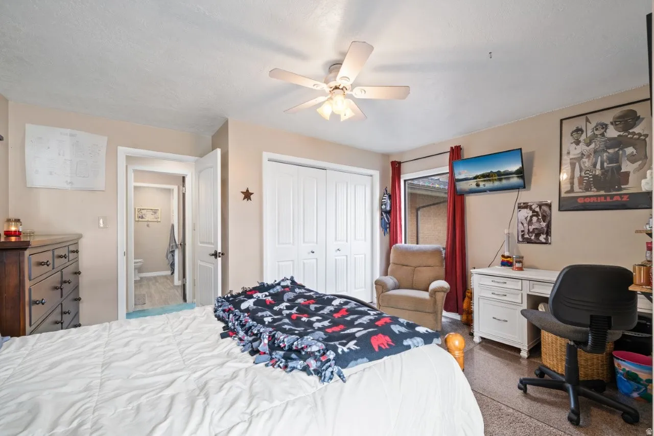 Bedroom with a closet, a ceiling fan, and a desk