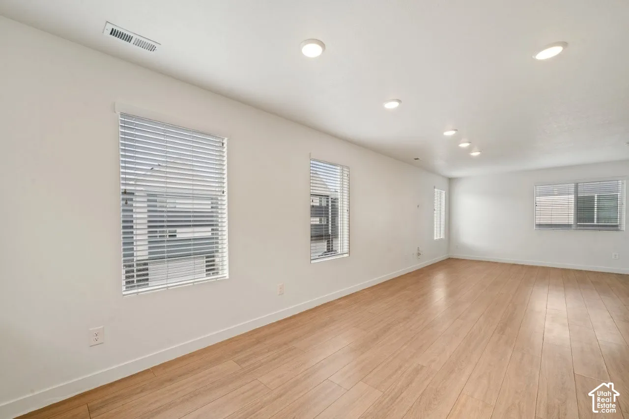 Empty room with light wood-type flooring and recessed lighting