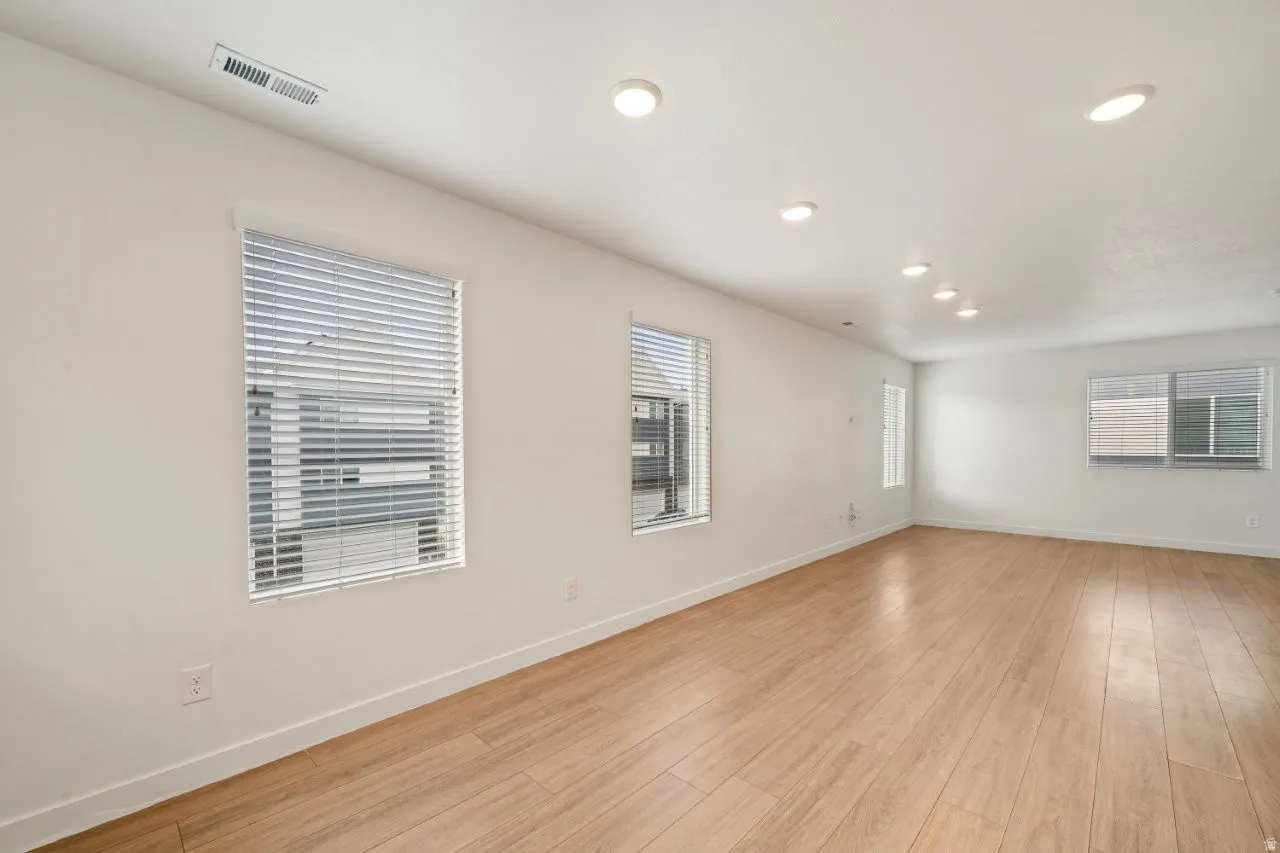Empty room with light wood-type flooring and recessed lighting