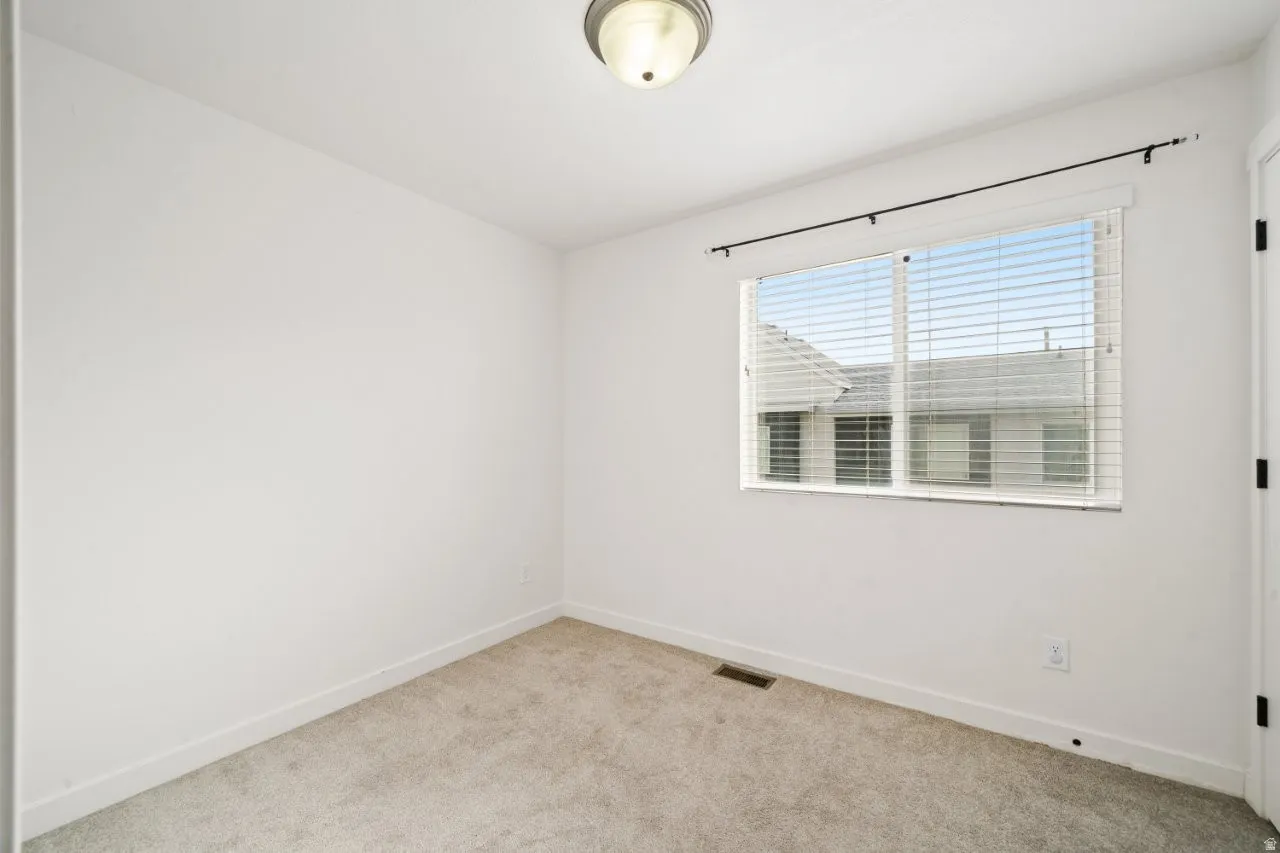 Spare room featuring baseboards and light colored carpet