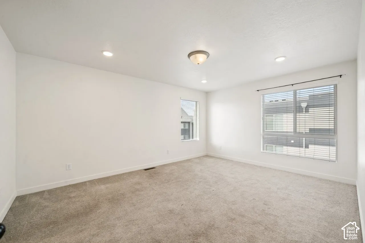 Unfurnished room featuring light carpet and recessed lighting