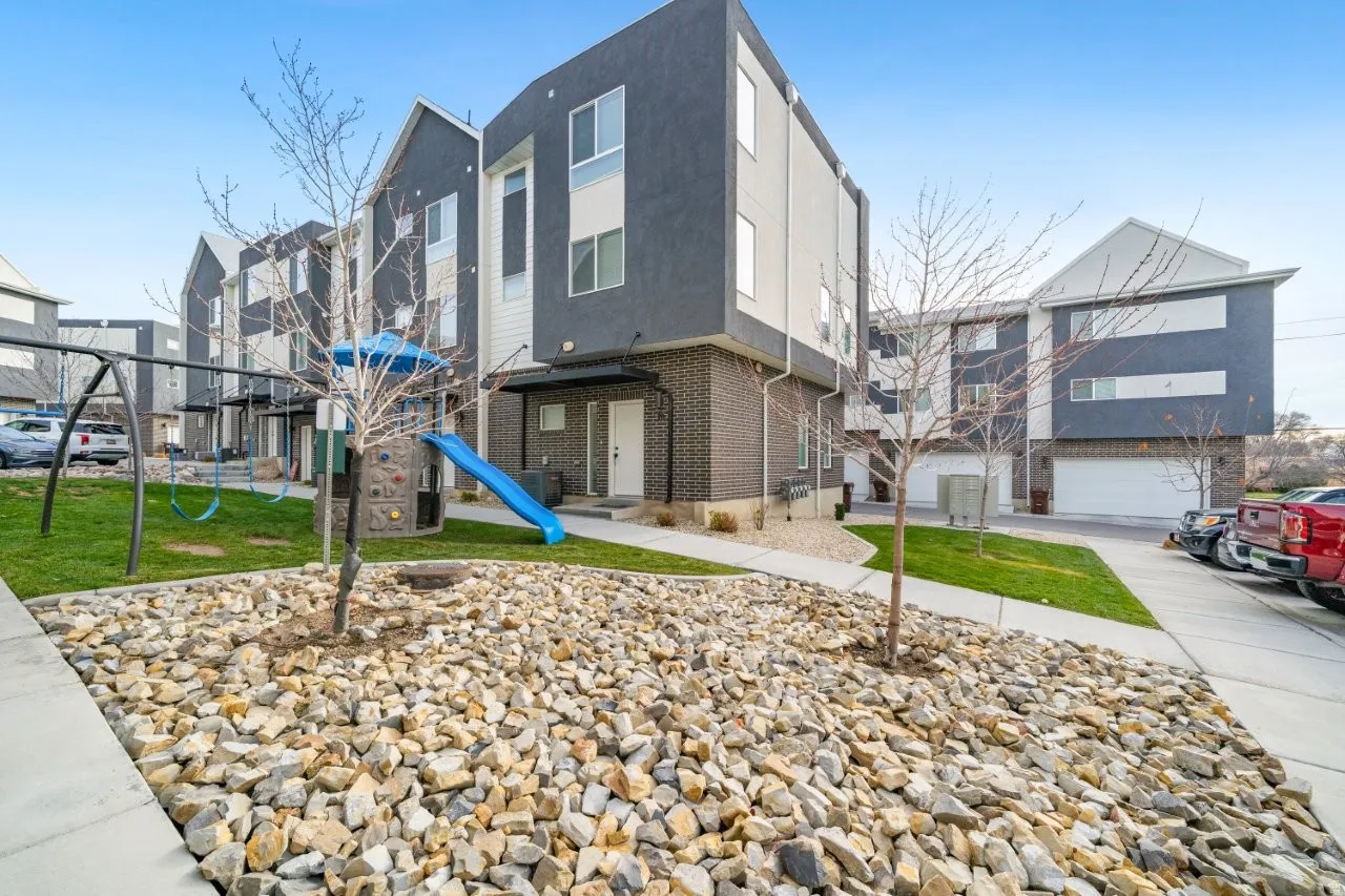 Contemporary home with stucco siding, brick siding, a front yard, and a residential view