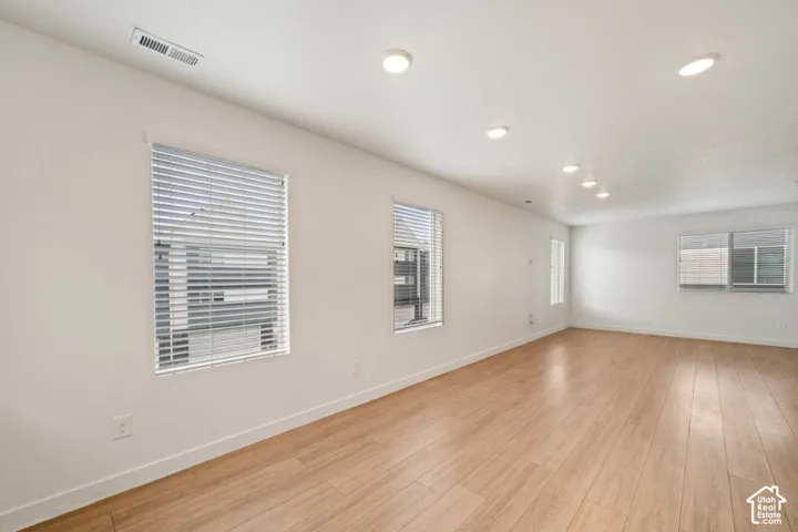 Empty room with light wood-type flooring and recessed lighting