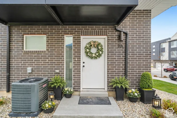 Property entrance featuring brick siding and covered porch