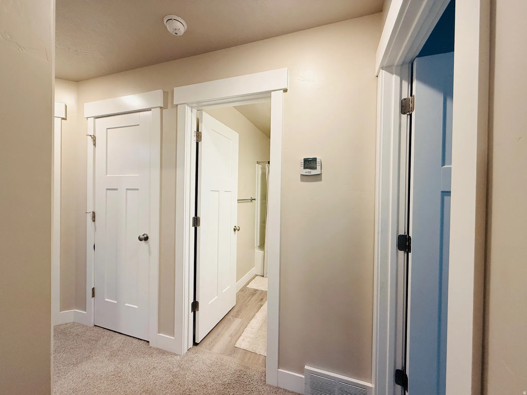 Hall featuring baseboards and light colored carpet