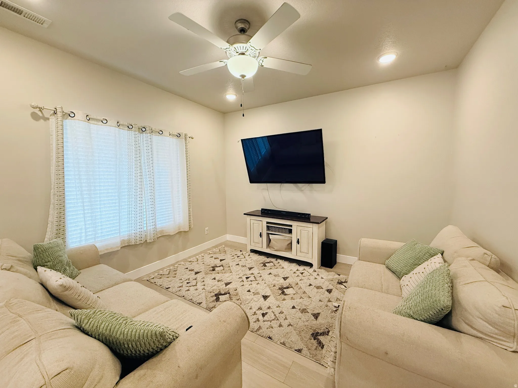 Living room featuring recessed lighting, a ceiling fan, and light wood-style flooring
