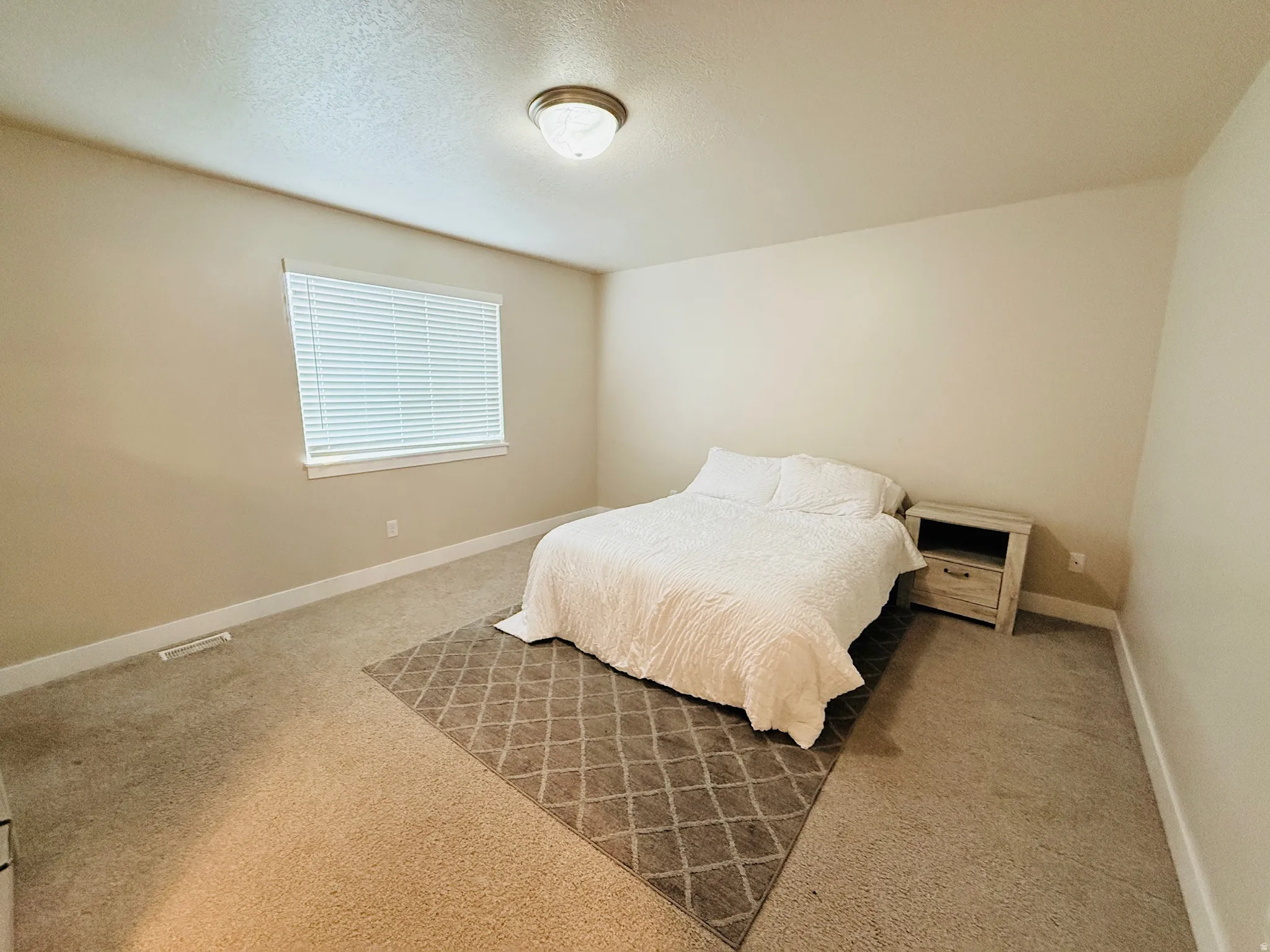 Bedroom featuring a textured ceiling and carpet flooring