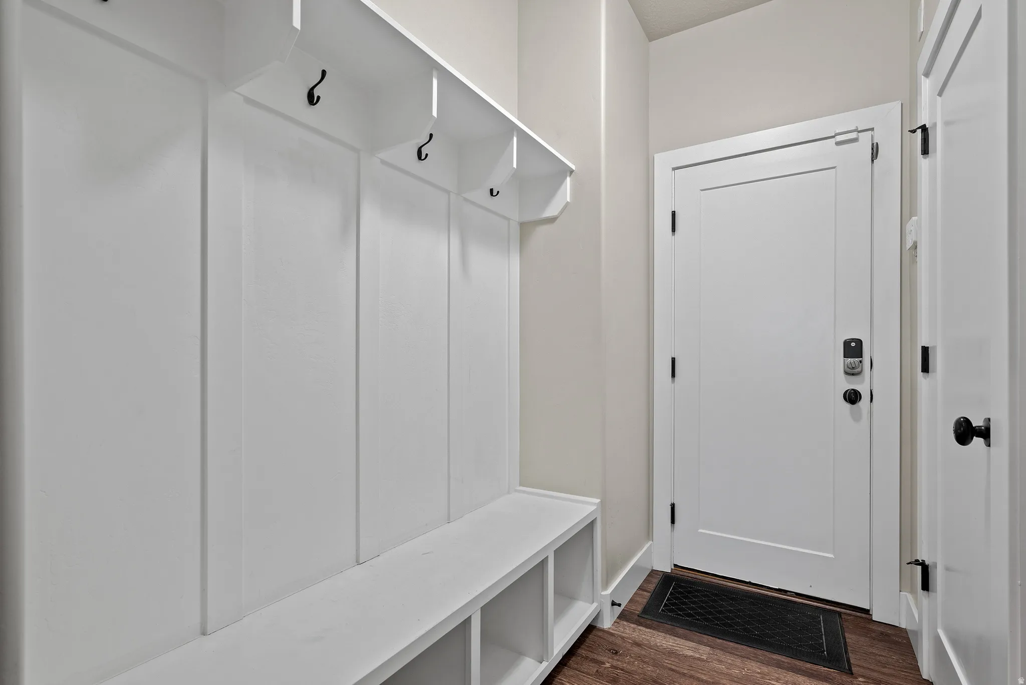 Mudroom with dark wood-style flooring and baseboards