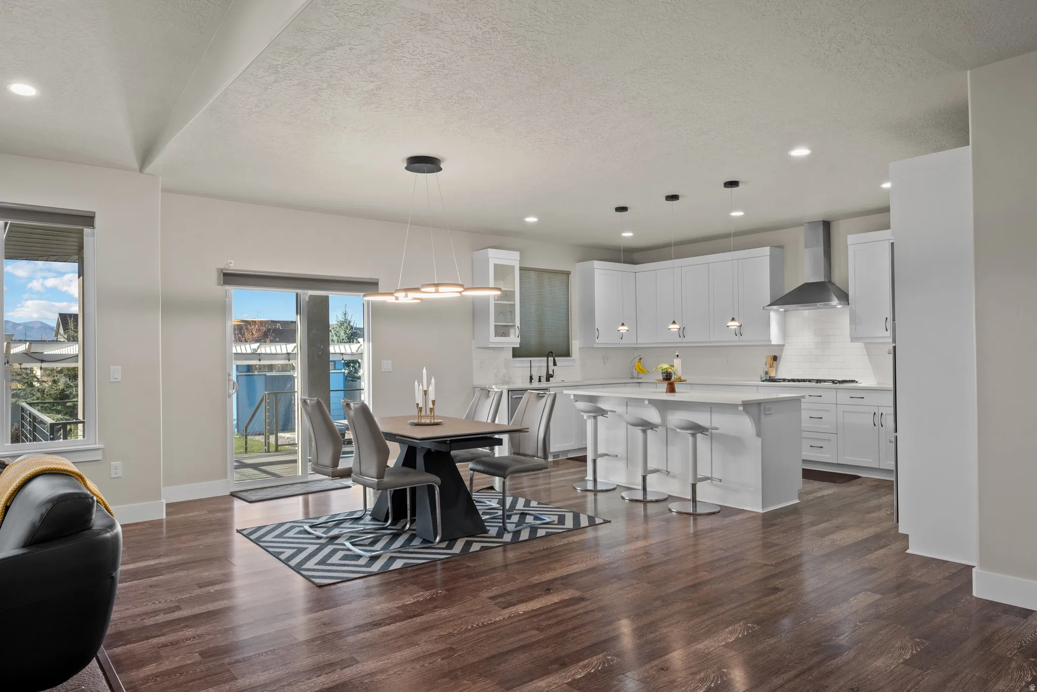 Dining area with recessed lighting, a textured ceiling, and dark wood-style flooring