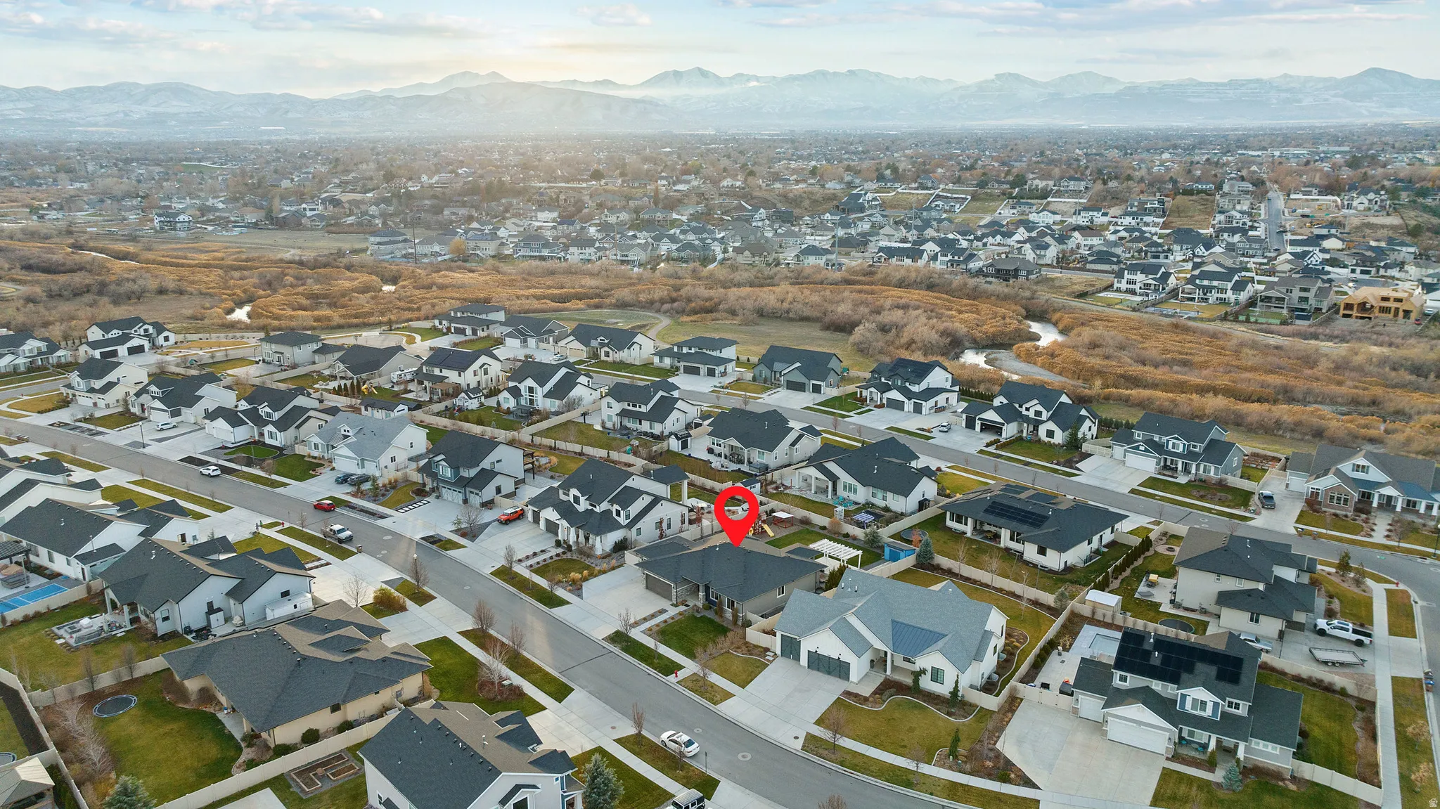 Aerial overview of property's location with nearby suburban area and a mountain backdrop