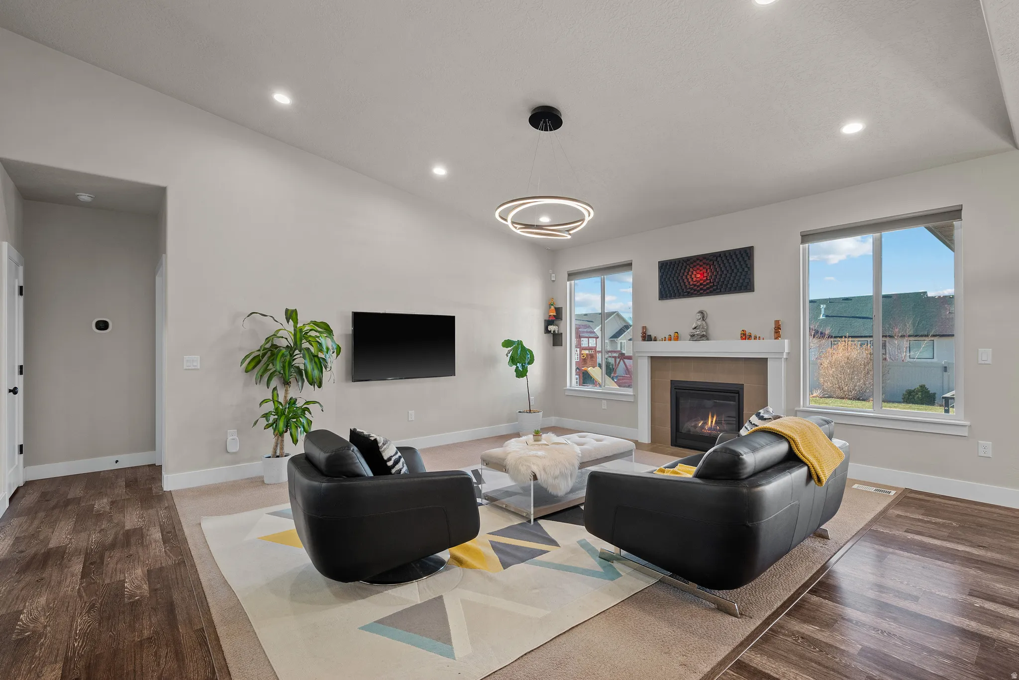 Living area with a tile fireplace, recessed lighting, dark wood-style flooring, and vaulted ceiling