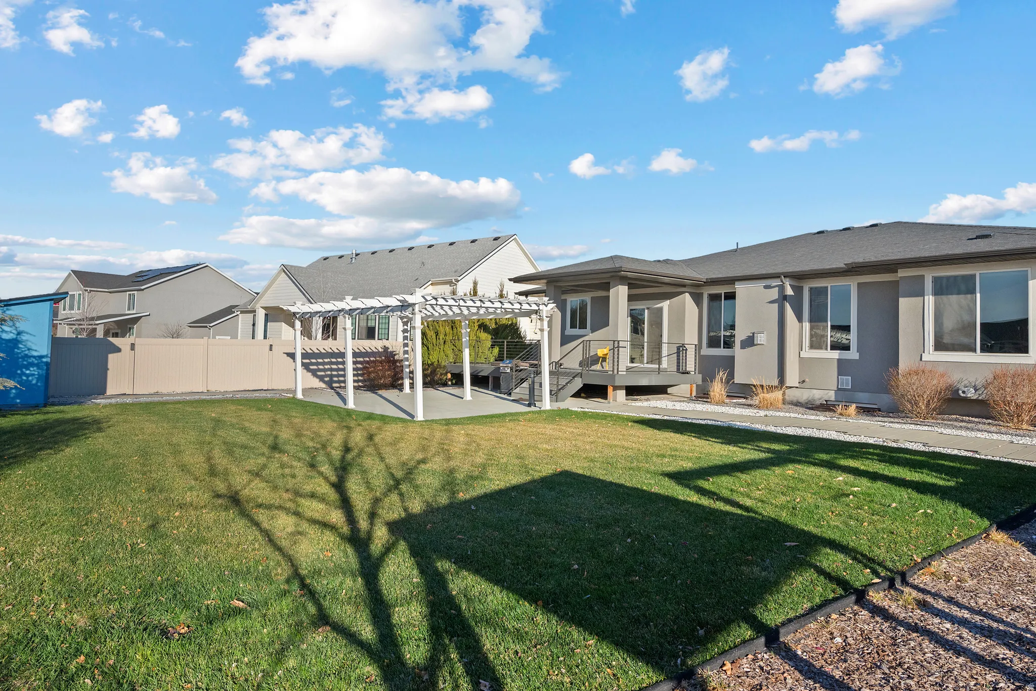 Rear view of property with a patio area, a pergola, and stucco siding
