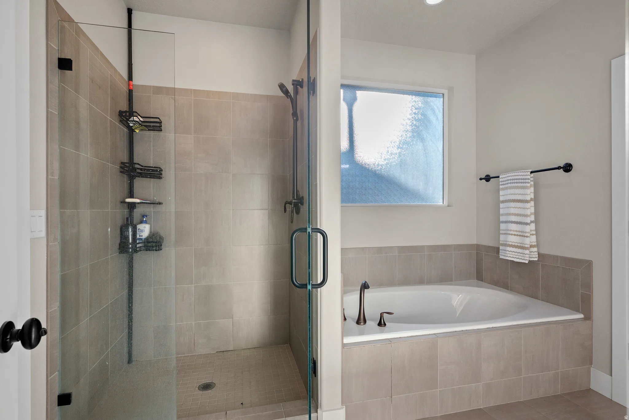 Bathroom featuring a garden tub and a shower stall