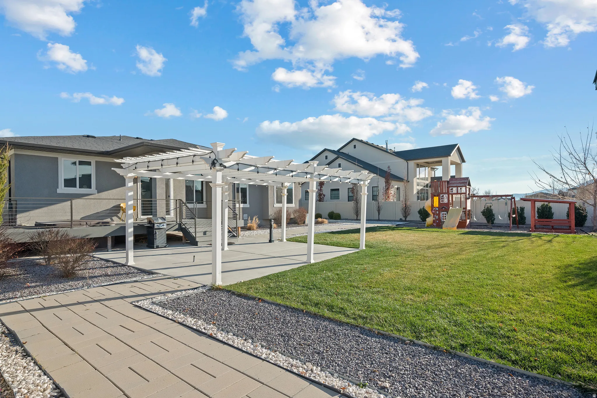 Rear view of house with a pergola, a patio area, a playground, and a yard