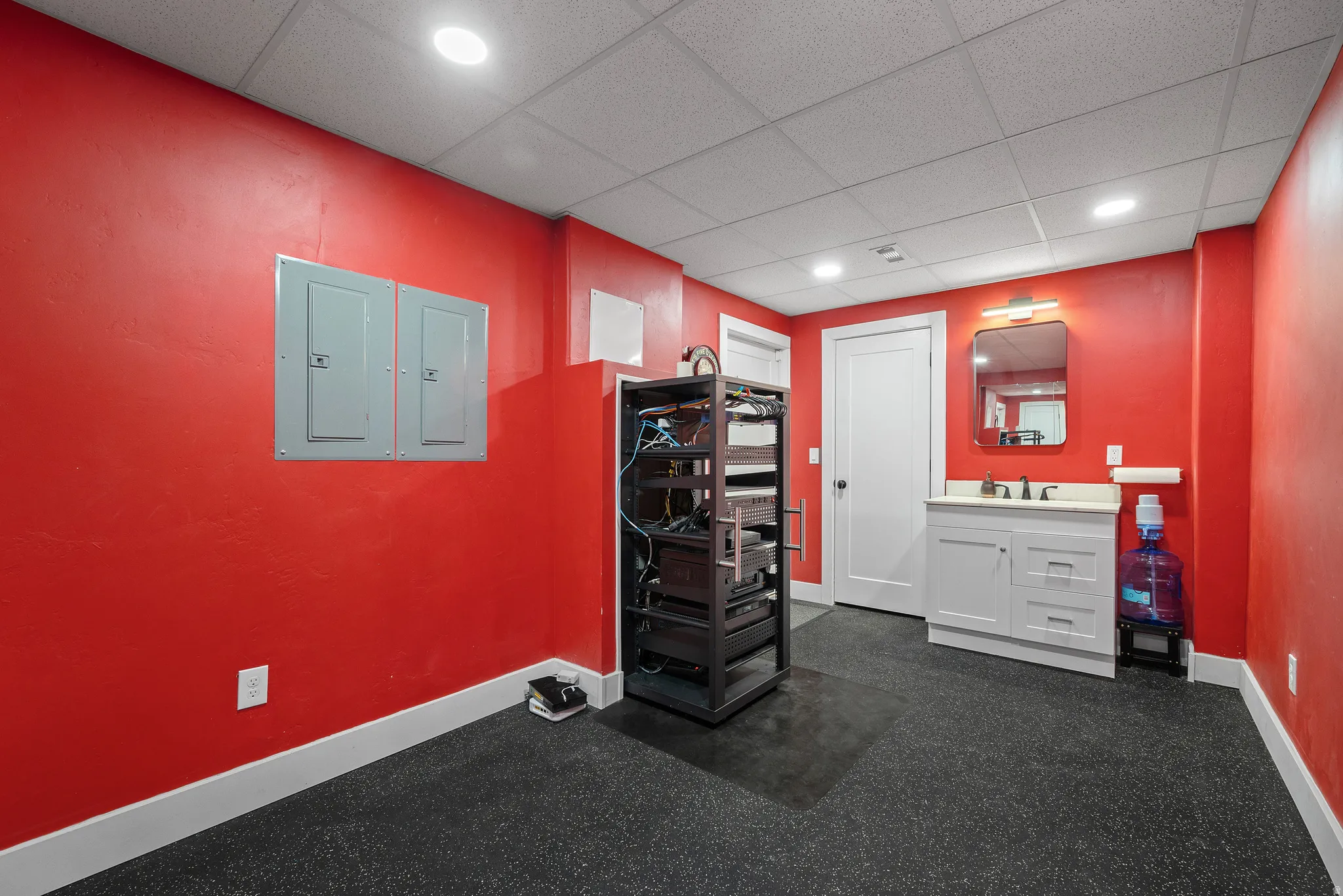 Exercise area featuring a drop ceiling, electric panel, and recessed lighting