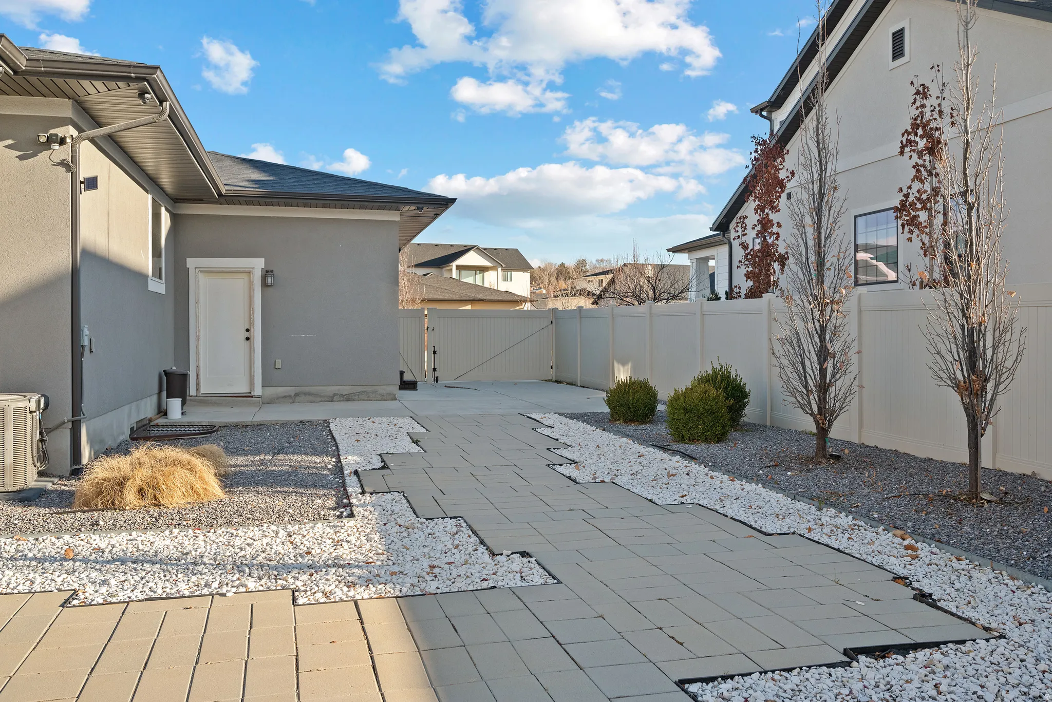 Fenced backyard featuring a gate and a patio