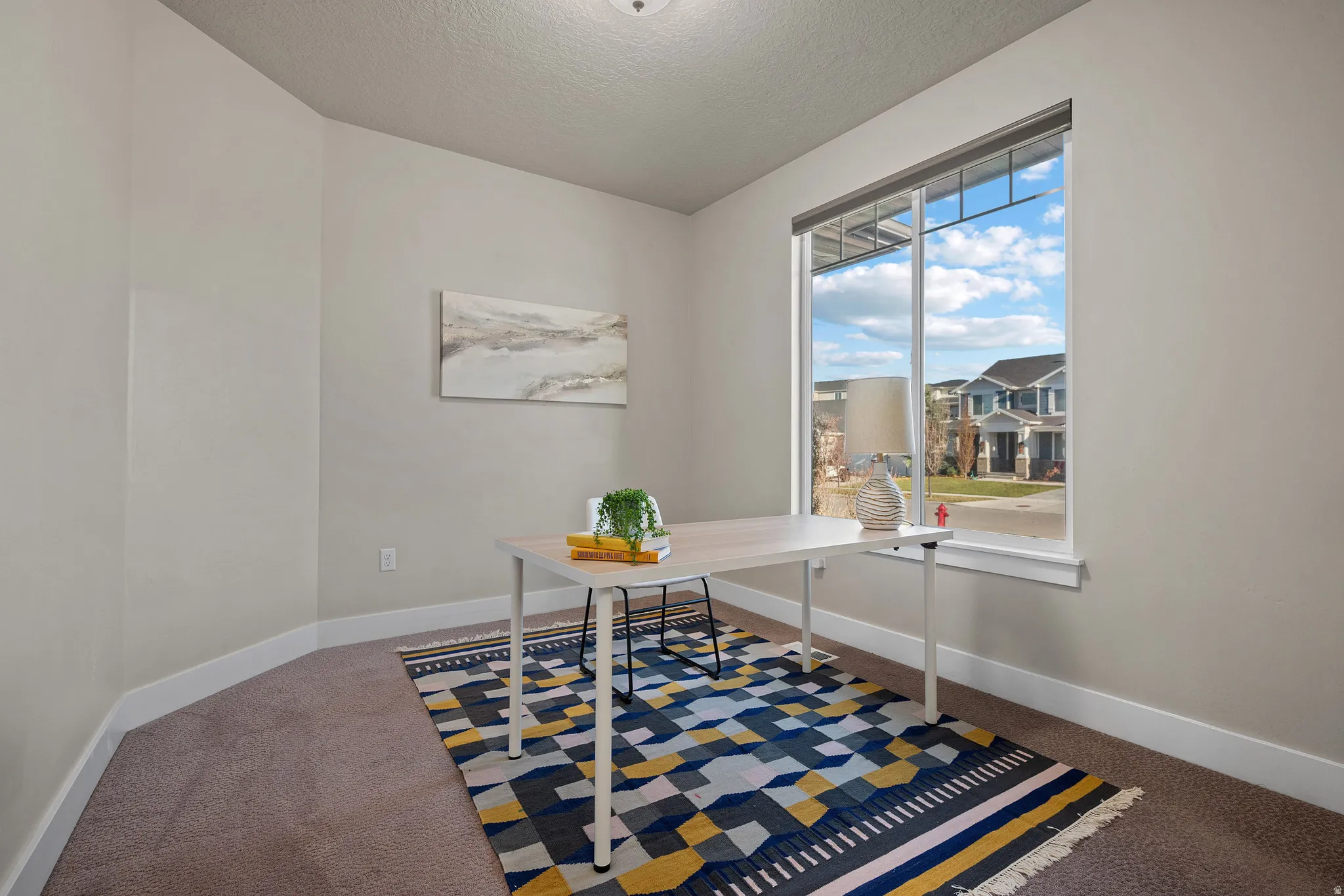 Home office with a textured ceiling and carpet floors