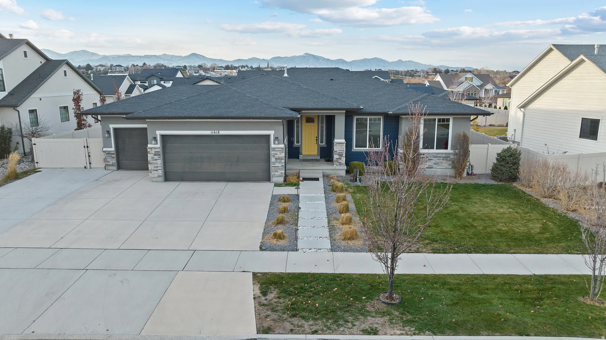 View of front facade with a residential view, concrete driveway, an attached garage, stone siding, and a mountain view