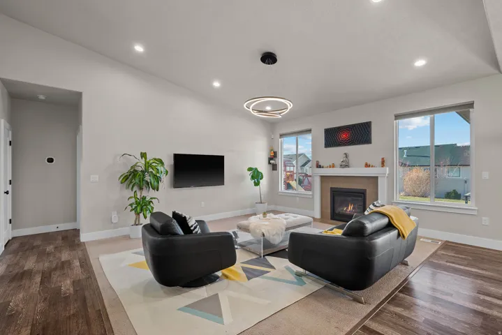 Living area with a tile fireplace, recessed lighting, dark wood-style flooring, and vaulted ceiling
