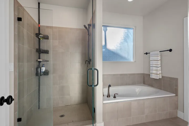 Bathroom featuring a garden tub and a shower stall