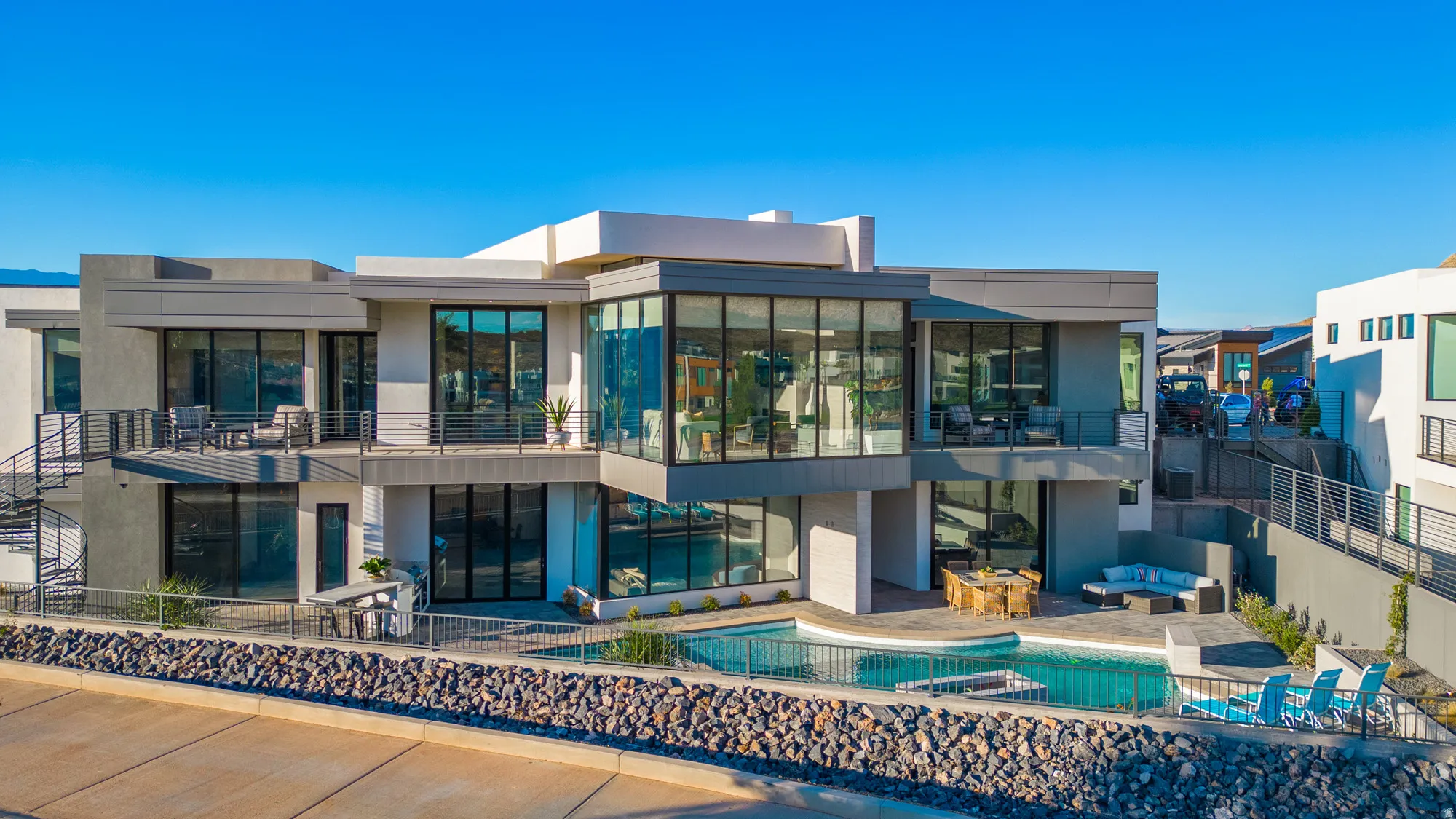 Back of house with a patio, a pool with connected hot tub, a balcony, outdoor lounge area, and stucco siding