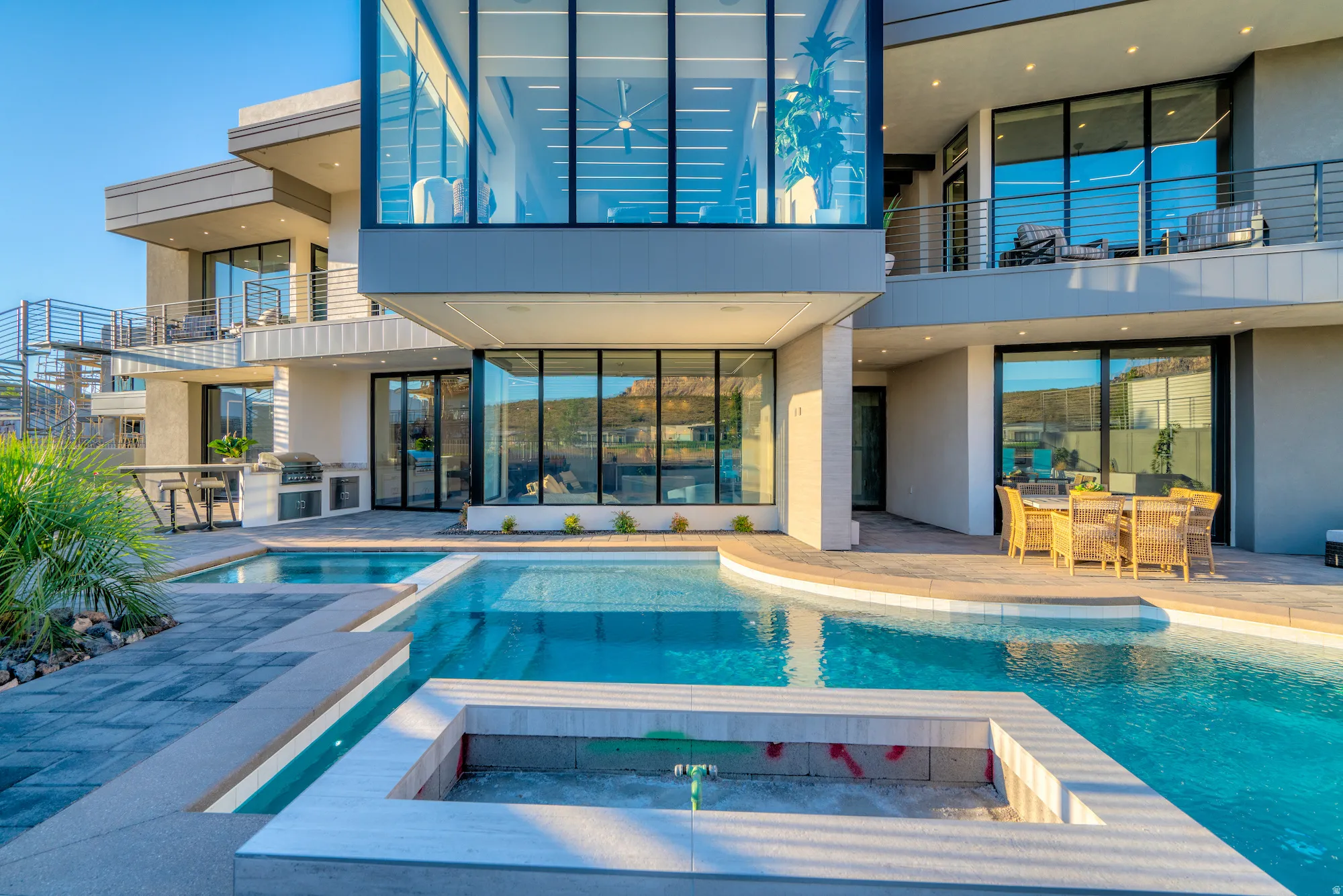 View of pool featuring area for grilling, a balcony, a patio area, outdoor dining space, and a pool with connected hot tub