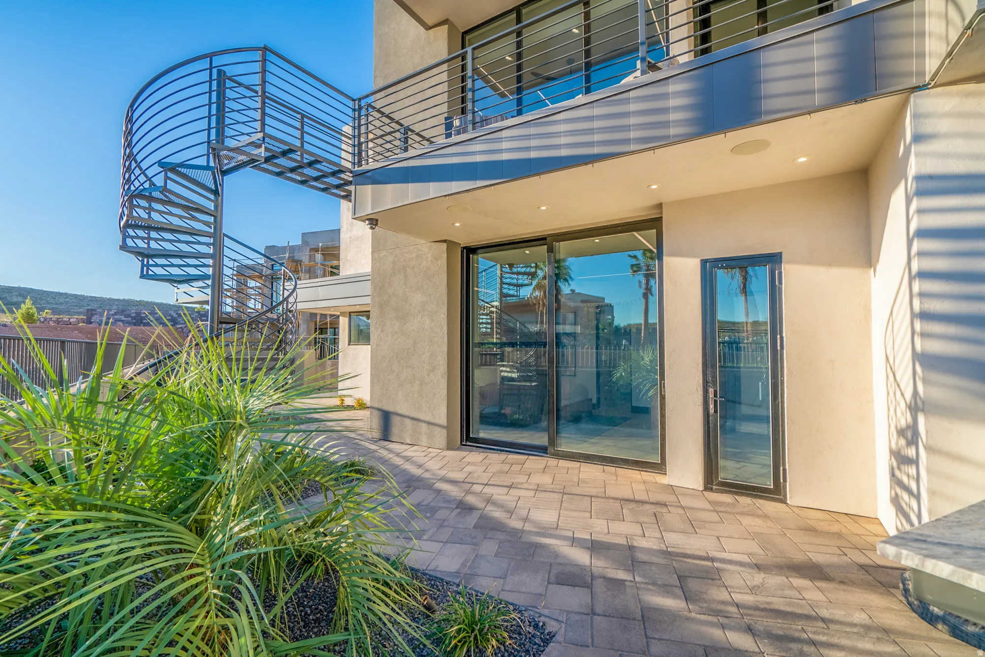 Property entrance with stucco siding and a patio
