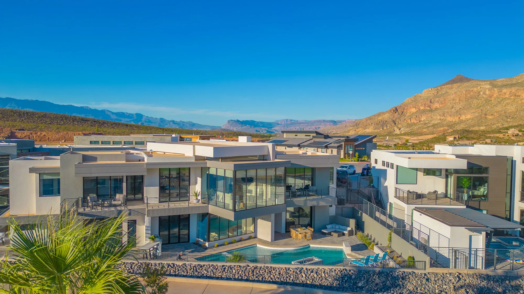 Back of property featuring a balcony, a mountain view, a patio, stucco siding, and a fenced backyard