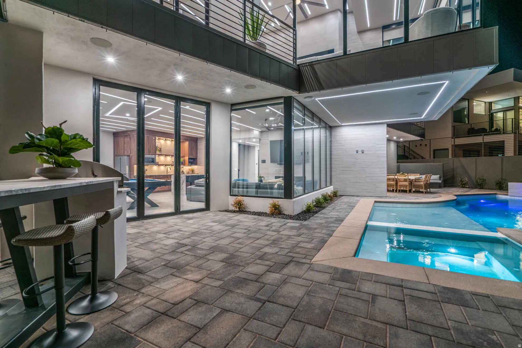 View of pool featuring a balcony, outdoor dining area, a patio, and a pool with connected hot tub